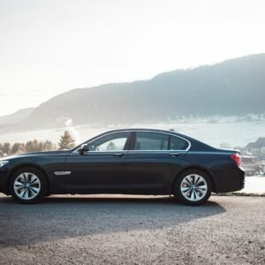 blue sedan on gray asphalt road during daytime